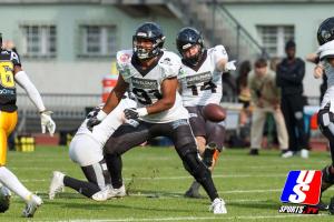 Kris Cain (Berlin Rebels, #14) kickt den Ball.